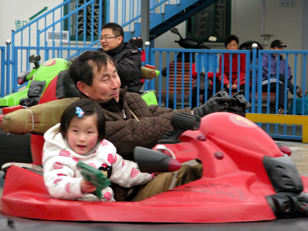 Dad and daughter having fun in the bumper cars